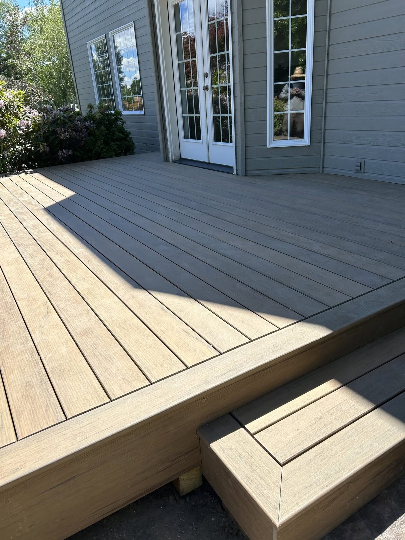 Low profile composite deck wrapping a back patio door