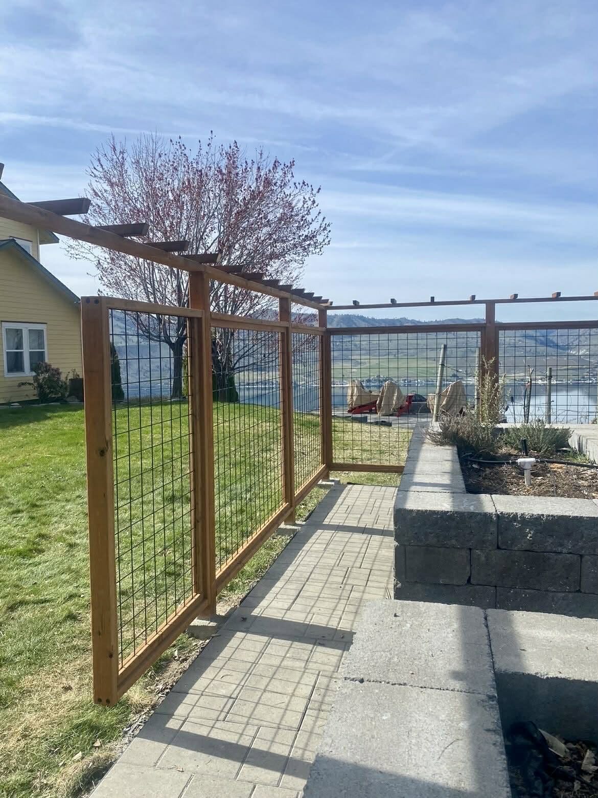 Deer proof garden enclosure with hog wire panels and a cedar pergola top in Chelan