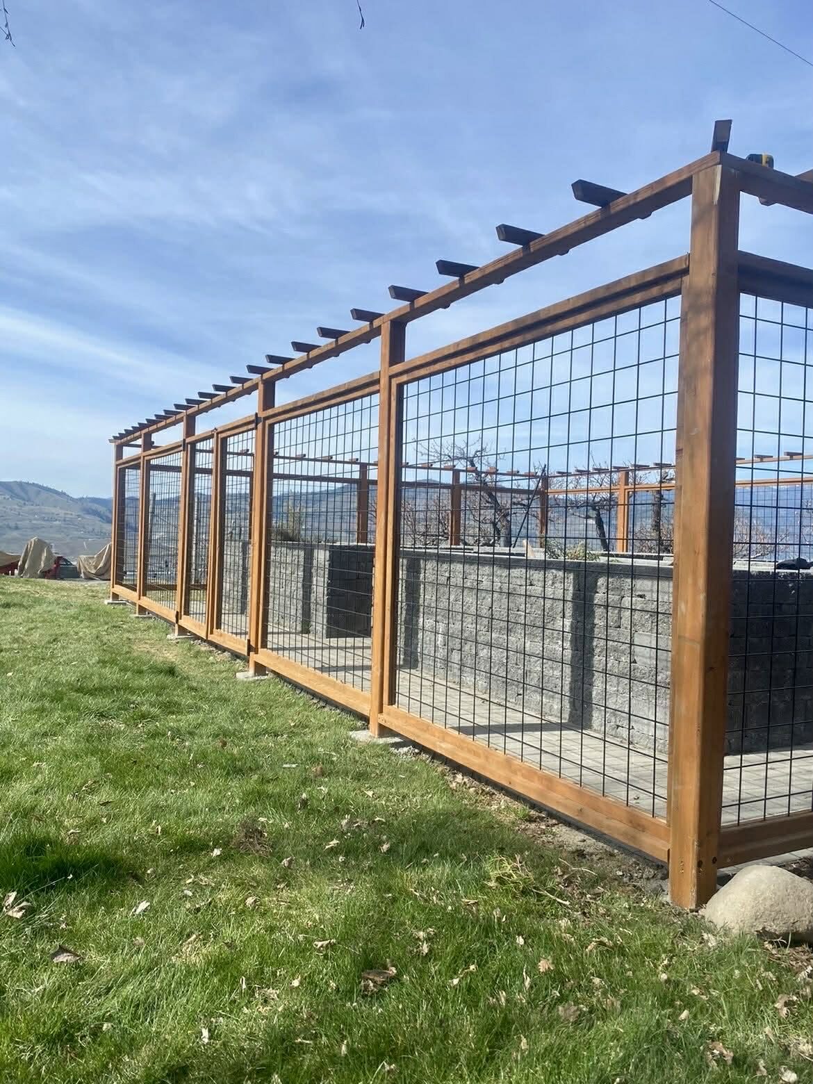 Deer proof garden enclosure with hog wire panels and a cedar pergola top in Chelan