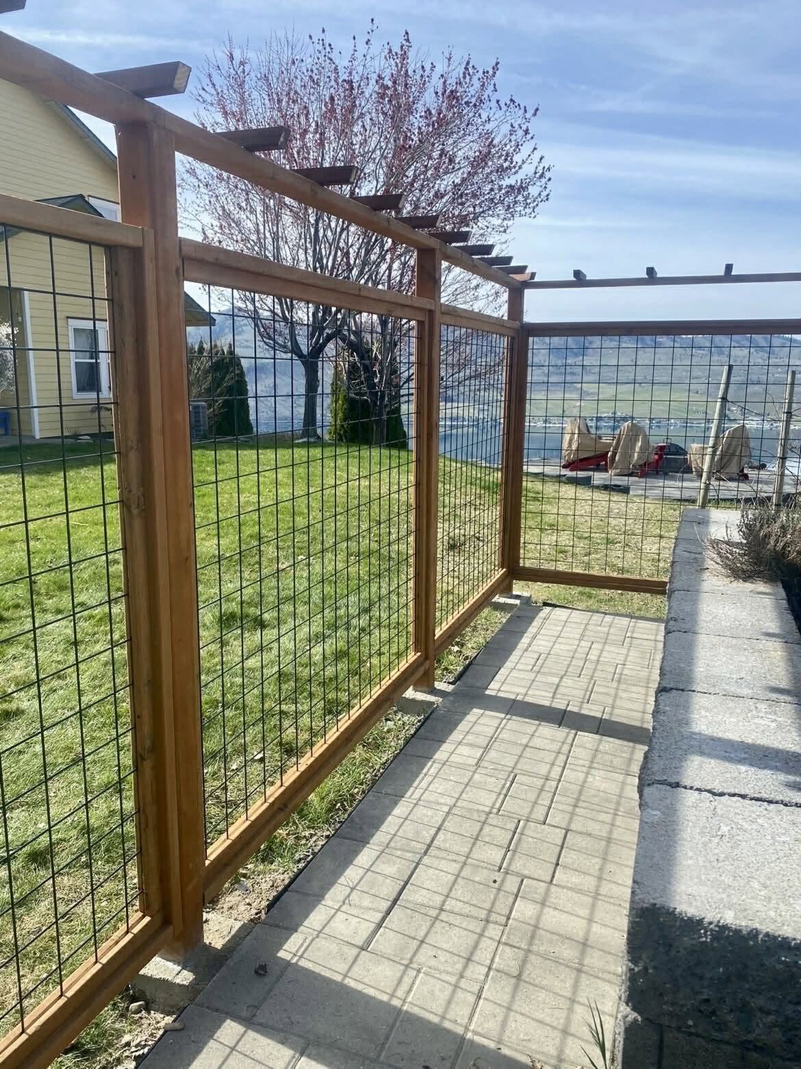 Deer proof garden enclosure with hog wire panels and a cedar pergola top in Chelan